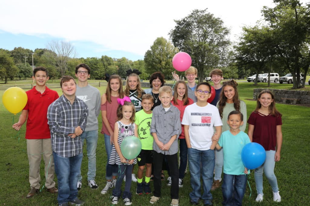 A group of children posing for a photo with balloons.