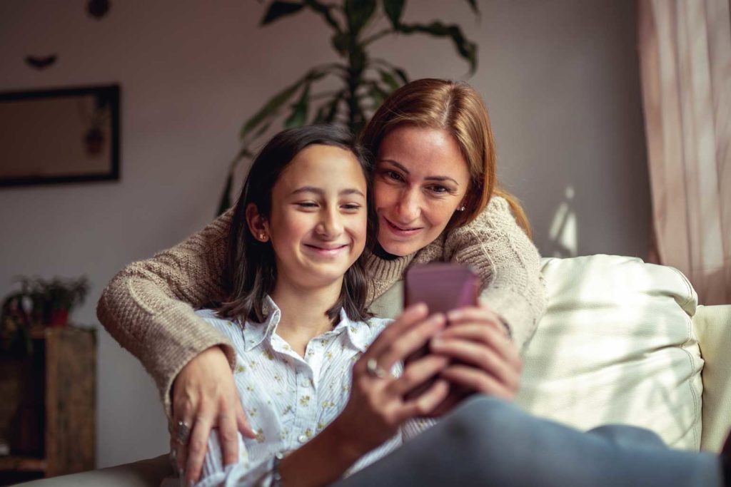 a mom and daughter using a phone to access the invisalign teen app