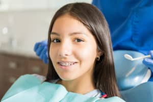 a teenage girl at the orthodontist getting braces care treatment