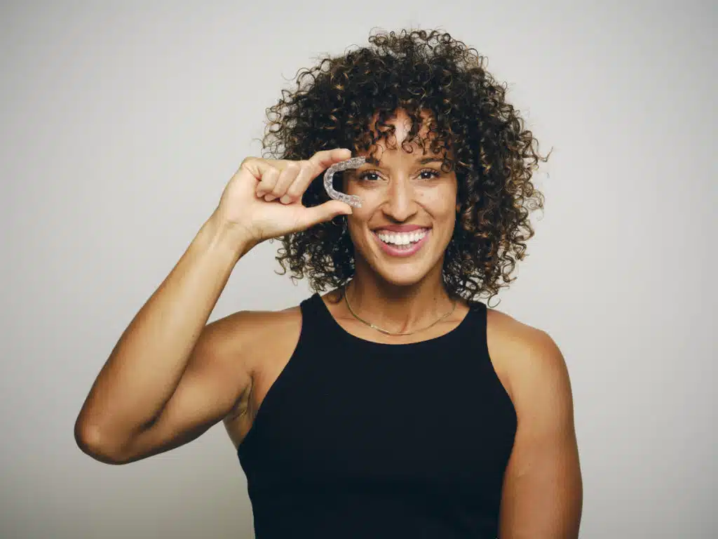 a female holding up spark aligners over her eye