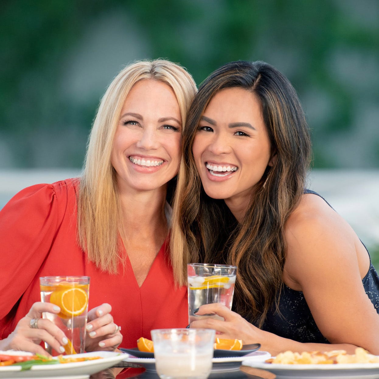 Two friends with clear braces in Nashville, TN smiling at lunch