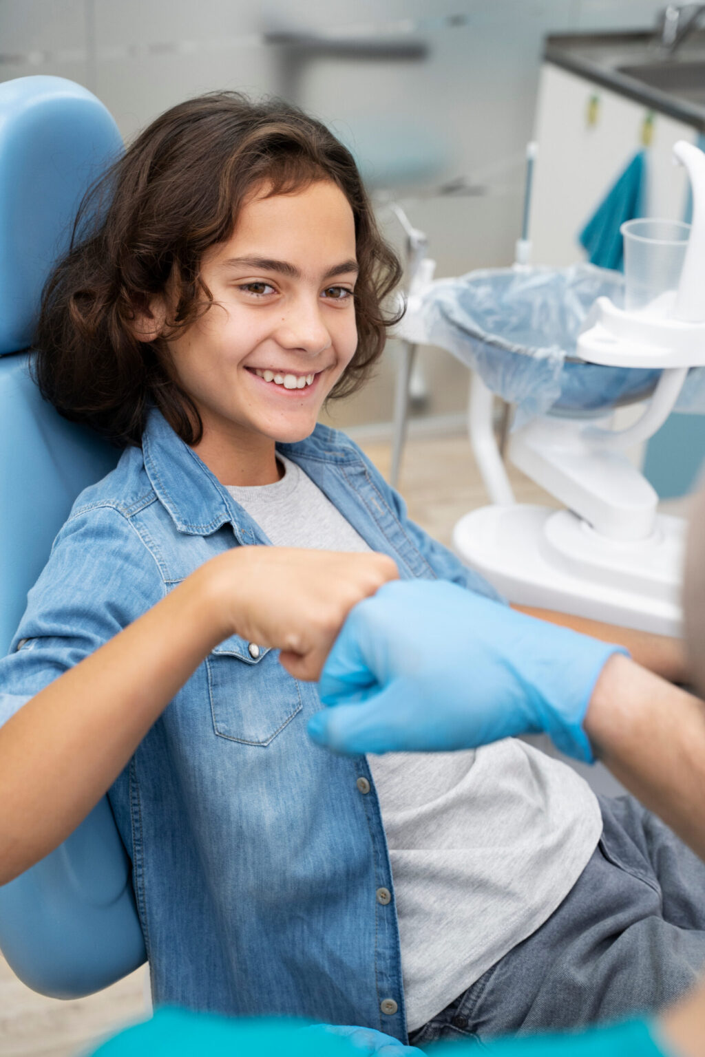 Young phase 1 orthodontics patient smiling and giving his orthodontist a fist bump