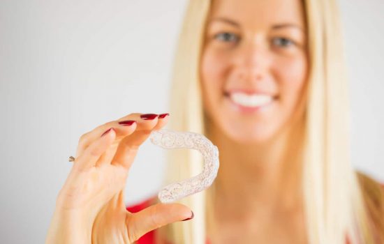 Woman holding teeth whitening tray, focus on whitening tray