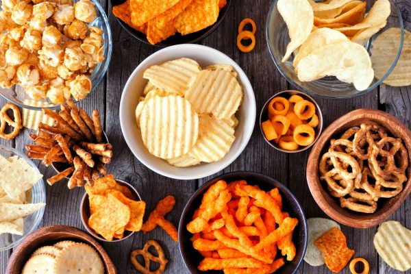 a top view image of a table with a lot of chips and other junk food